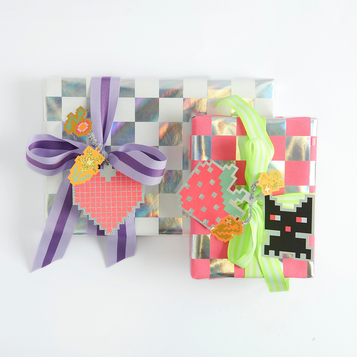 Paper Poetry Webband Duo Streifen Neon: Zwei Geschenke mit Schachbrettmuster und bunten Bändern, dekoriert mit floralen Anhängern.