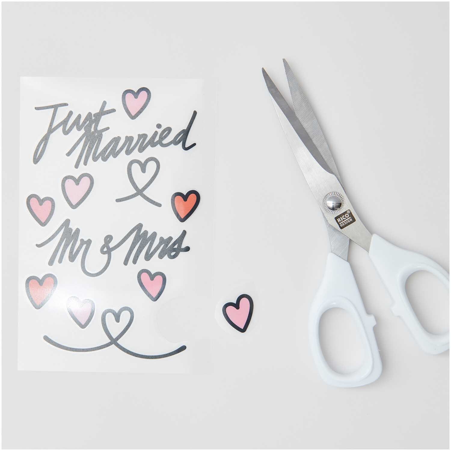Transfermotiv Just Married 10 Stück mit Herzen und Schere von Rico Design auf hellem Hintergrund.