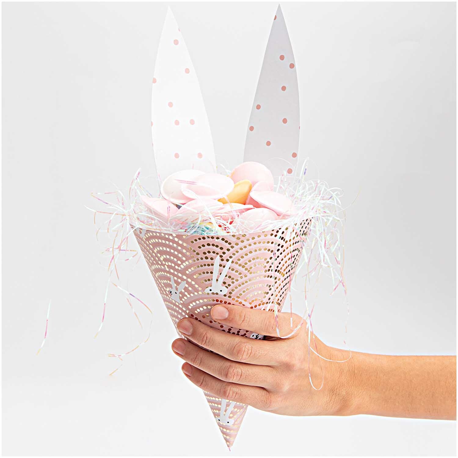 Paper Poetry Motivkarton Bunny Hop Hasen im Feld rosa 50x70cm, dekorativ gefaltet als Geschenkverpackung mit Hasenohren und buntem Inhalt.