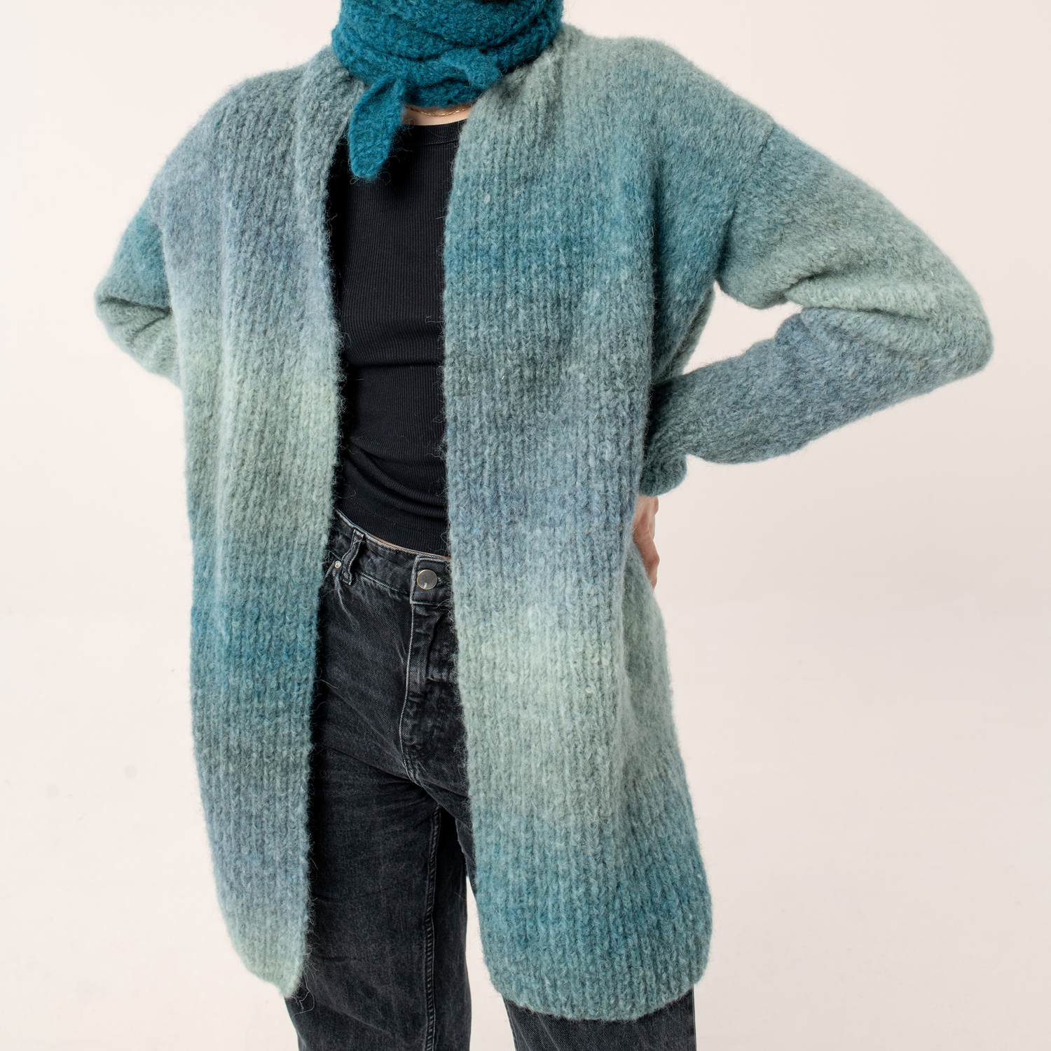 Strickanleitung Mantel aus Fashion Alpaca Superfine Heavens Big Cloud: Langer, blauer Strickmantel, kombiniert mit schwarzem Shirt und Jeans.