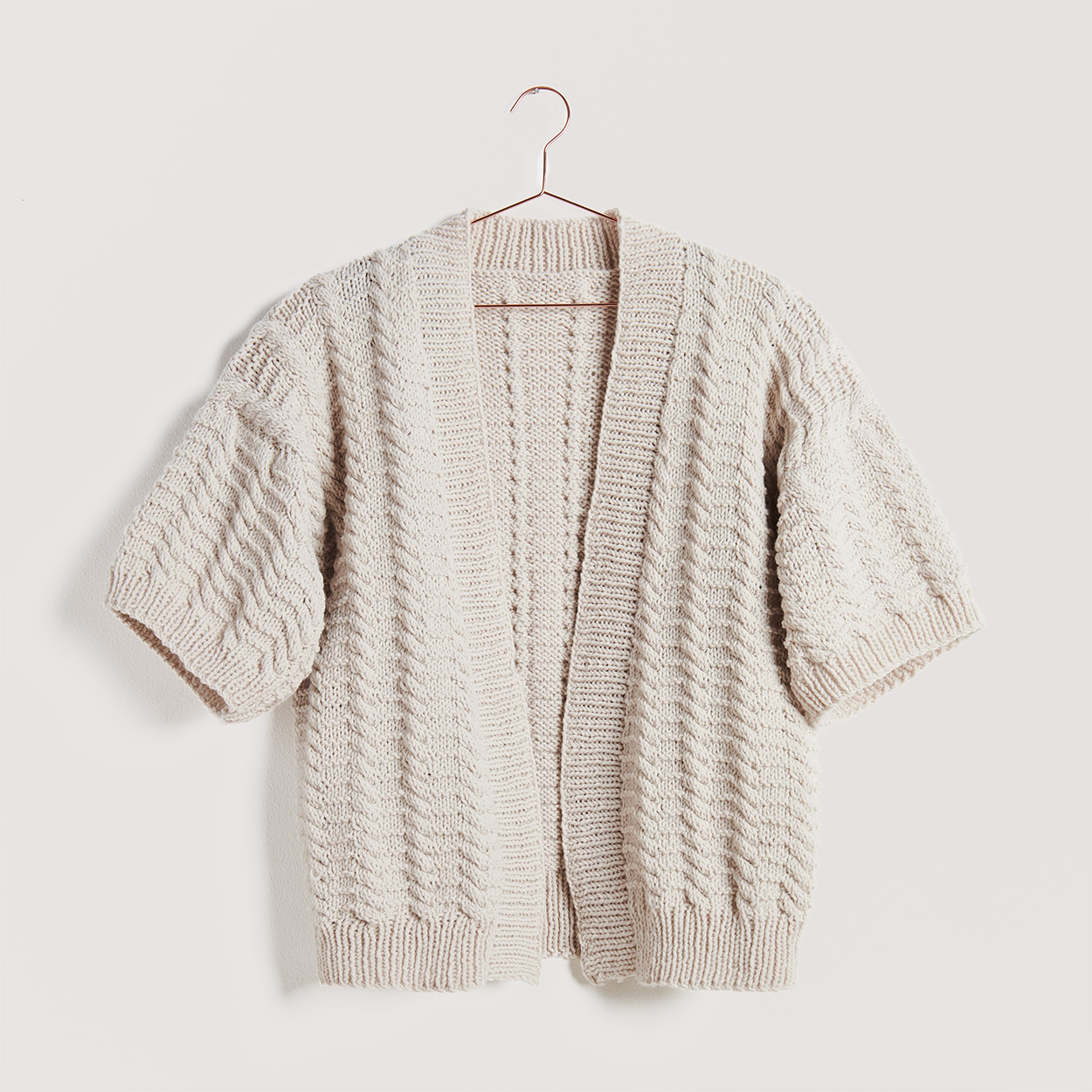 Cardigan auf grauem Hintergrund – zum Strickset