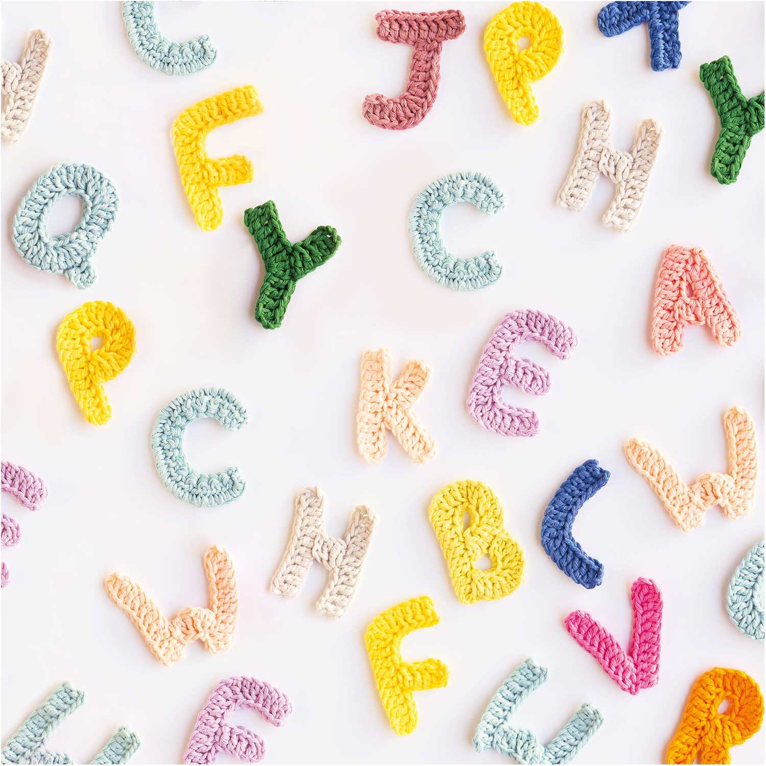 Creative Cotton aran: Bunte, gehäkelte Buchstaben auf weißem Hintergrund, ideal für kreative Projekte.