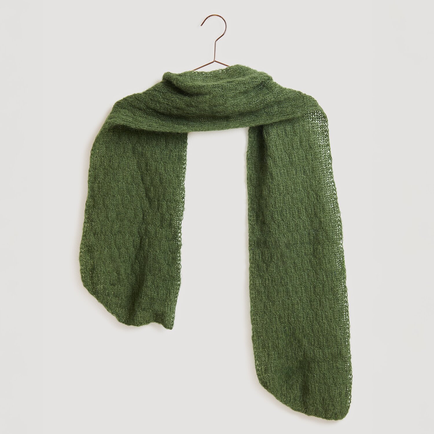Strickset Schal Modell 22 aus Die Neue Masche No. 13 in Oliv, gefertigt aus Alpaka-Baumwoll-Mischung, präsentiert auf einem Kleiderbügel.