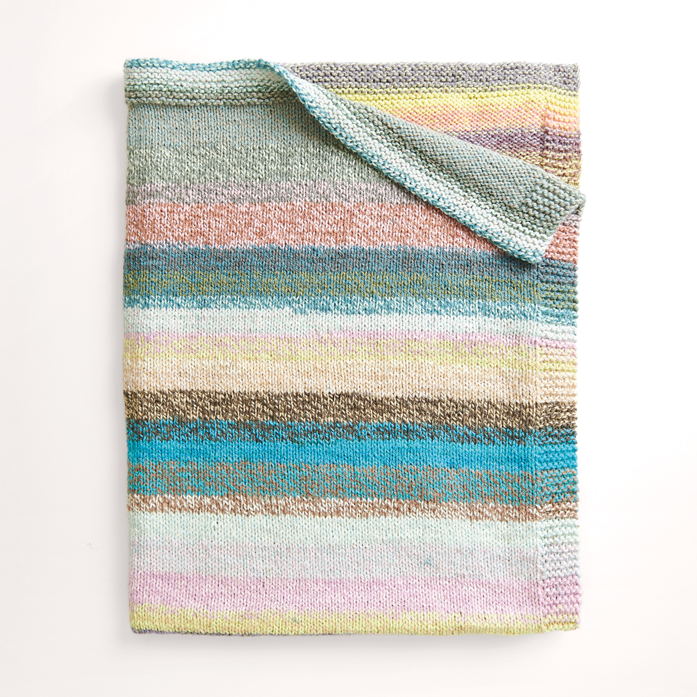 Gestreifte Decke auf grauem Hintergrund – zum Strickset 