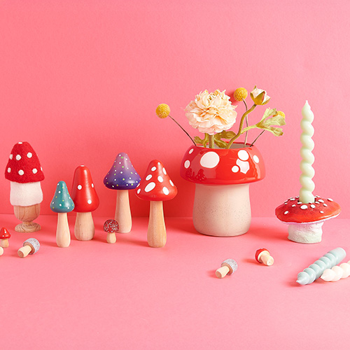 Holzdekoration, Blumenvase und Kerzenhalter in Fliegenpilzform. Fotosetting pinker Hintergrund.