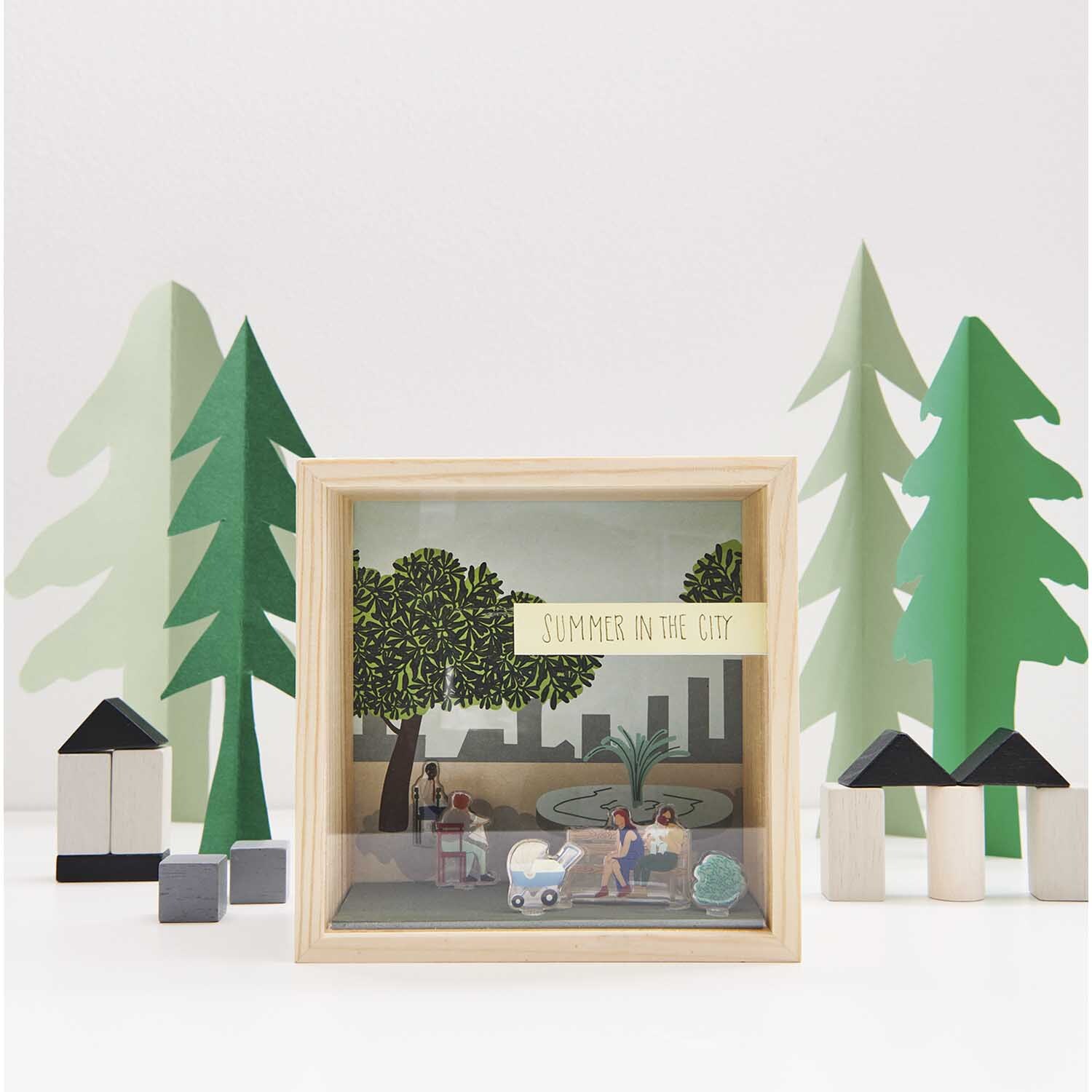 Figurico Gelsticker Parkbänke: Miniatur-Szene mit Bäumen und Figuren in einem Holzrahmen.