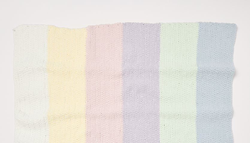 Häkelanleitung Regenbogen-Decke aus Creative Chenillove: Pastellfarbene Streifen in weicher Textur.