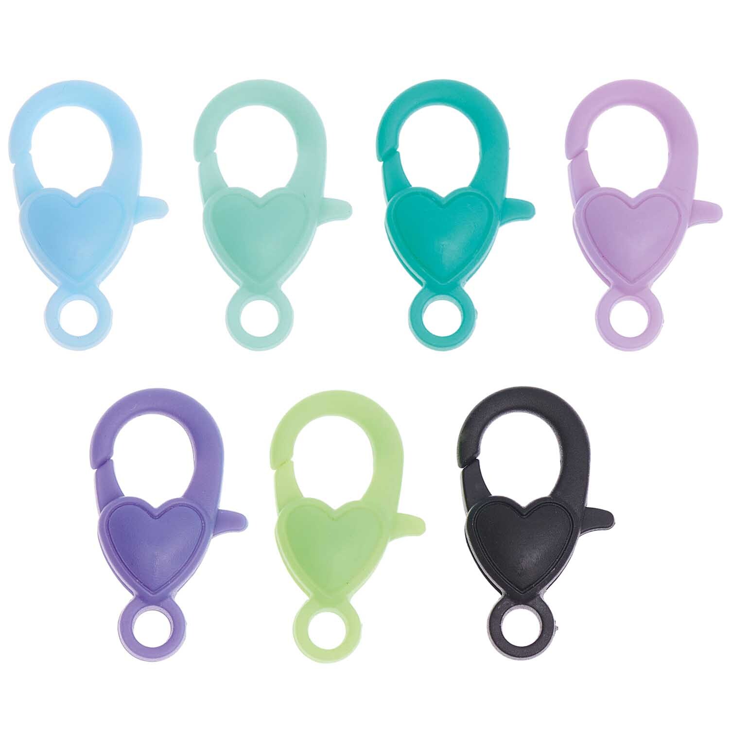 itoshii Karabiner Grün Mix: Sieben herzförmige Karabiner in verschiedenen Grüntönen, ideal für kreative Projekte.