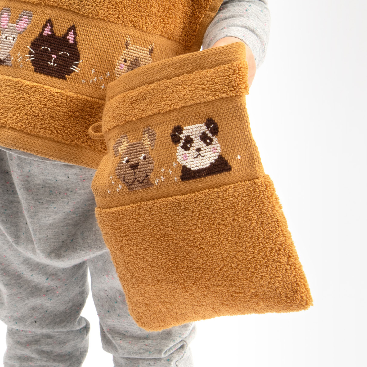 Stickanleitung Waschläppchen für Kinder mit Tiermotiven auf braunem Stoff, ideal für kreative Projekte.