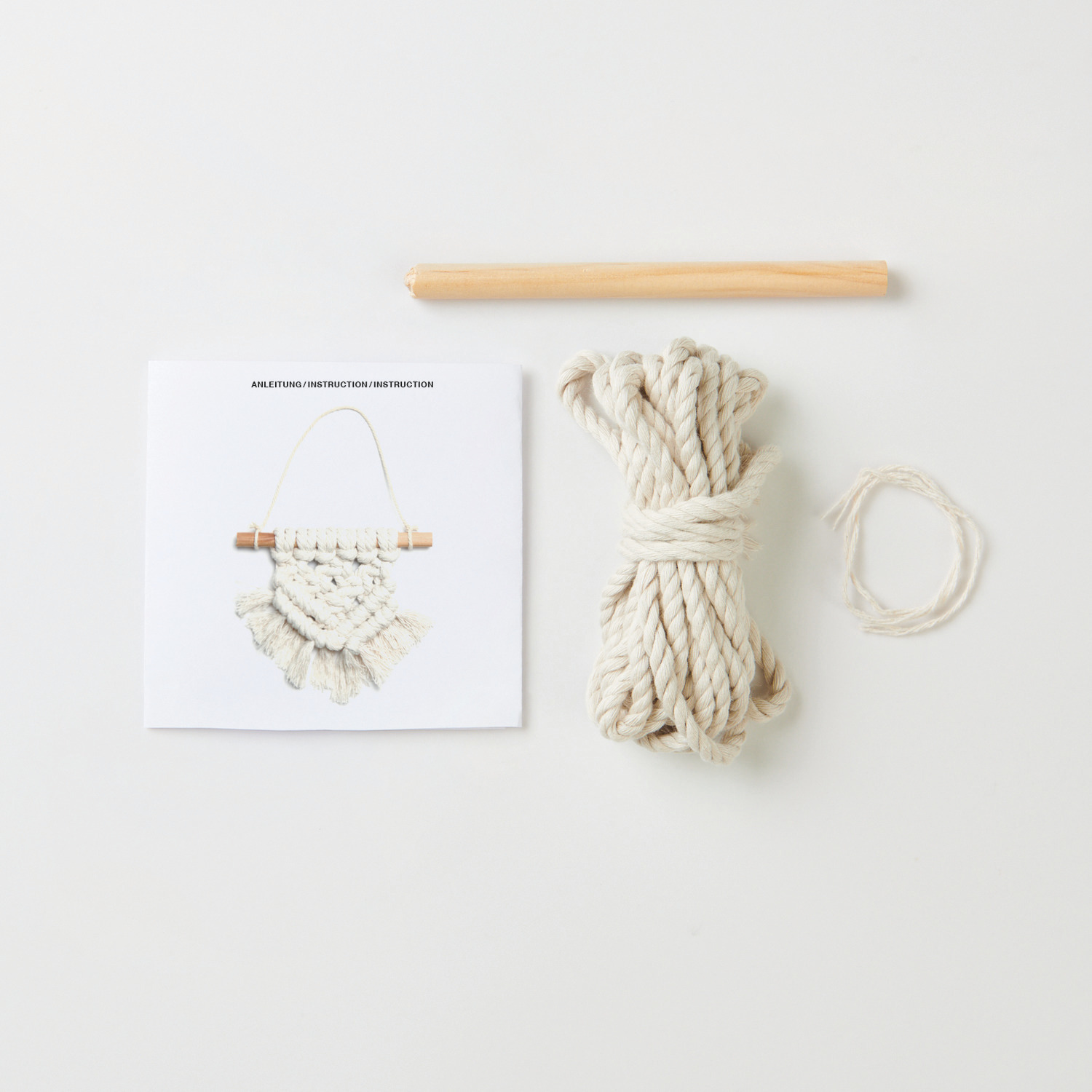 Makramee Set Wandbehang mit Anleitung, Seil und Holzstab von Rico Design auf weißem Hintergrund.