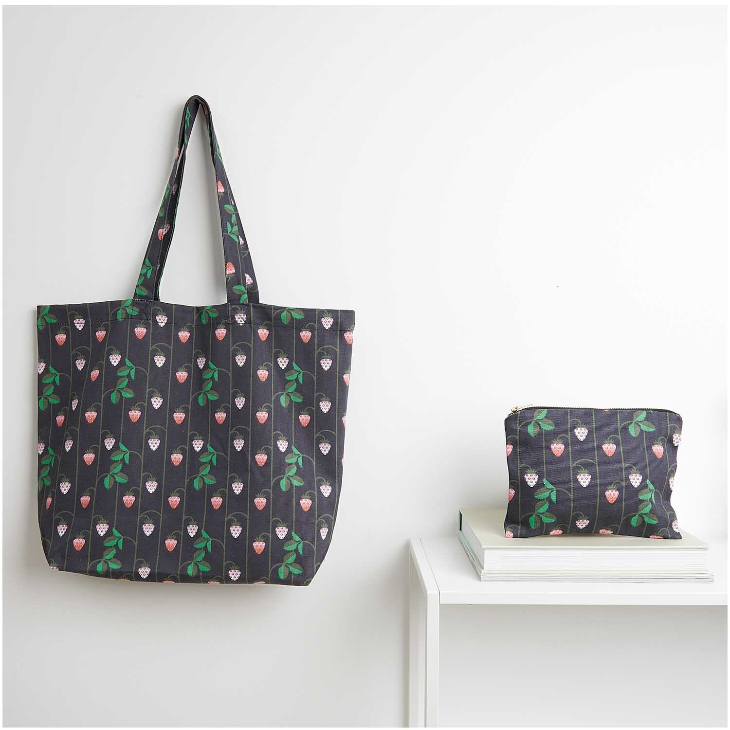 Canvas-Shopper Erdbeeren blau von Rico Design: Große Tasche mit Erdbeermuster neben passendem Etui auf weißem Tisch.