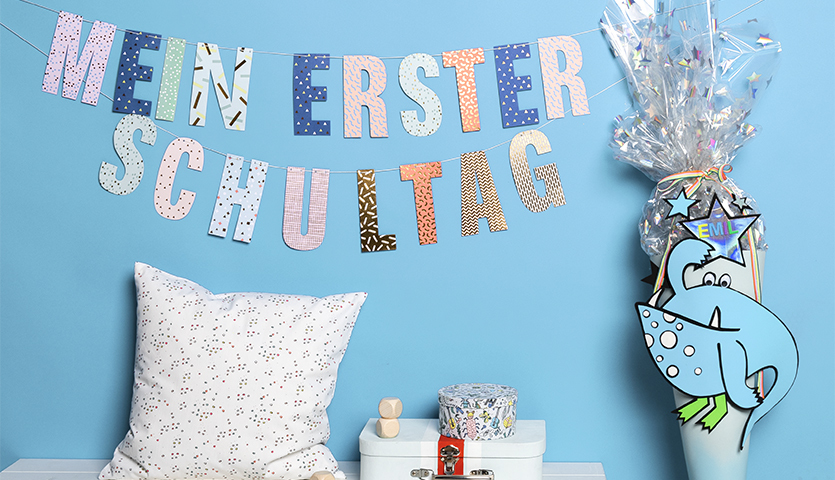 Bastelanleitung Monster-Schultüte für Jungen: Blaue Schultüte mit Monsterdesign, dekoriert für den ersten Schultag, vor blauem Hintergrund.