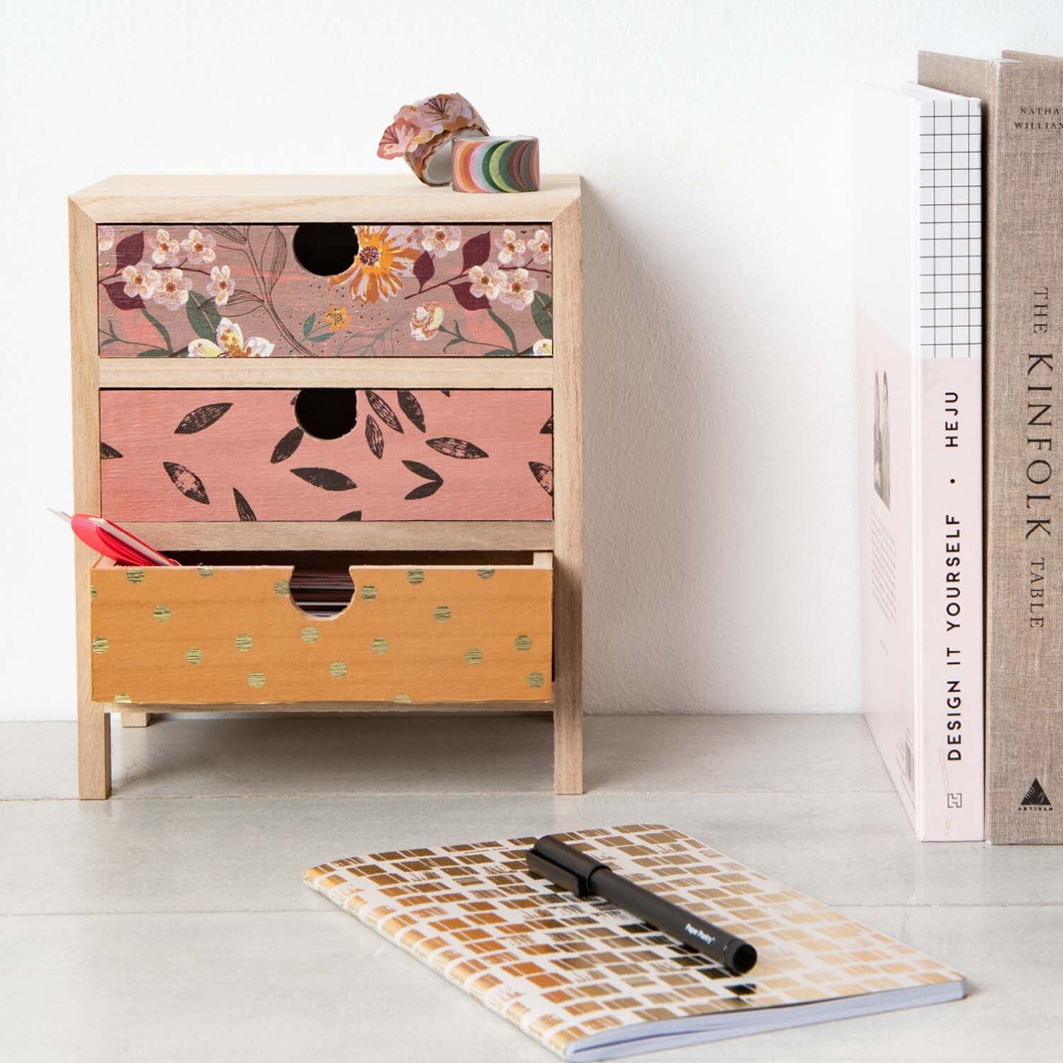 Bastelanleitung Schreibtischutensilien individualisieren: Dekorierte Schubladenbox mit floralen Mustern und Notizbuch auf einem Schreibtisch.