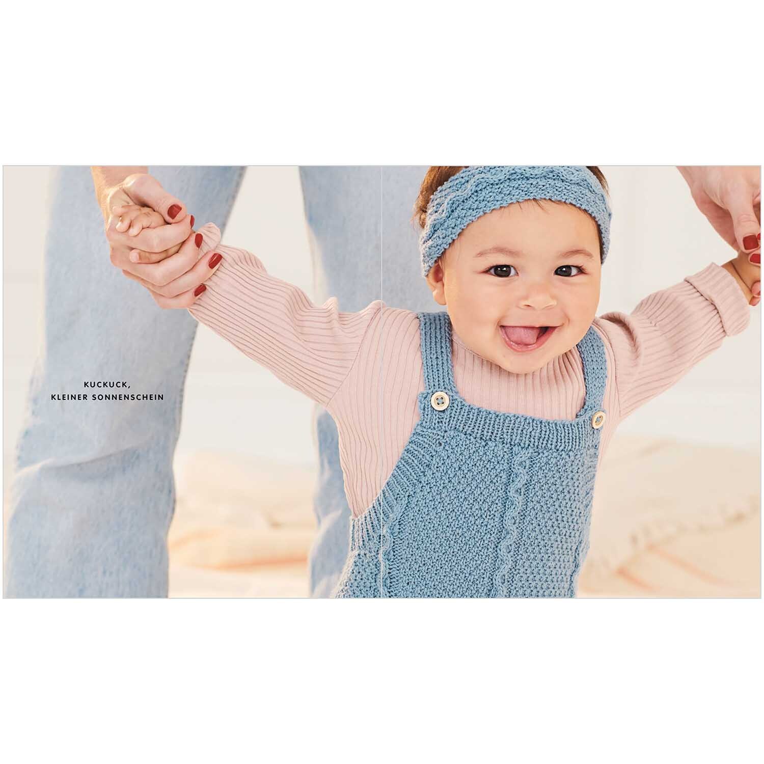 Baby Merino 01: Fröhliches Baby in blauer Strickkleidung von Rico Design, gehalten von Erwachsenen.