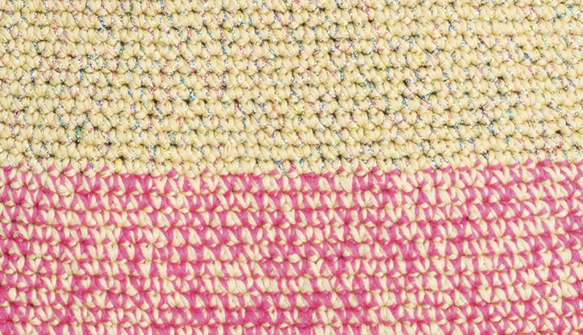 Häkelanleitung Tasche mit funkelndem Beilaufgarn: Nahaufnahme von gehäkeltem Stoff in Beige und Pink.