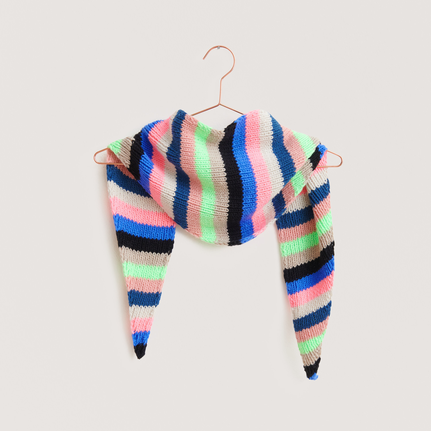 Strickset Dreieckstuch Modell 05b aus Vegan Cashmere in bunten Streifen auf einem Bügel.