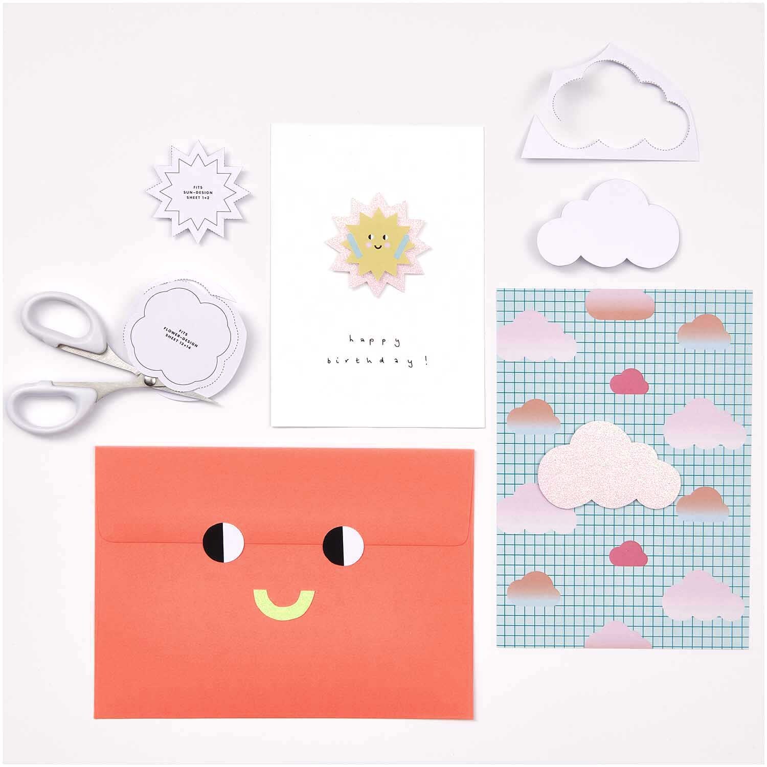 Paper Poetry Motivpapierblock Happy Birthday 23 Blatt zeigt farbenfrohe Karten und Umschläge mit Wolken- und Sonnenmotiven.
