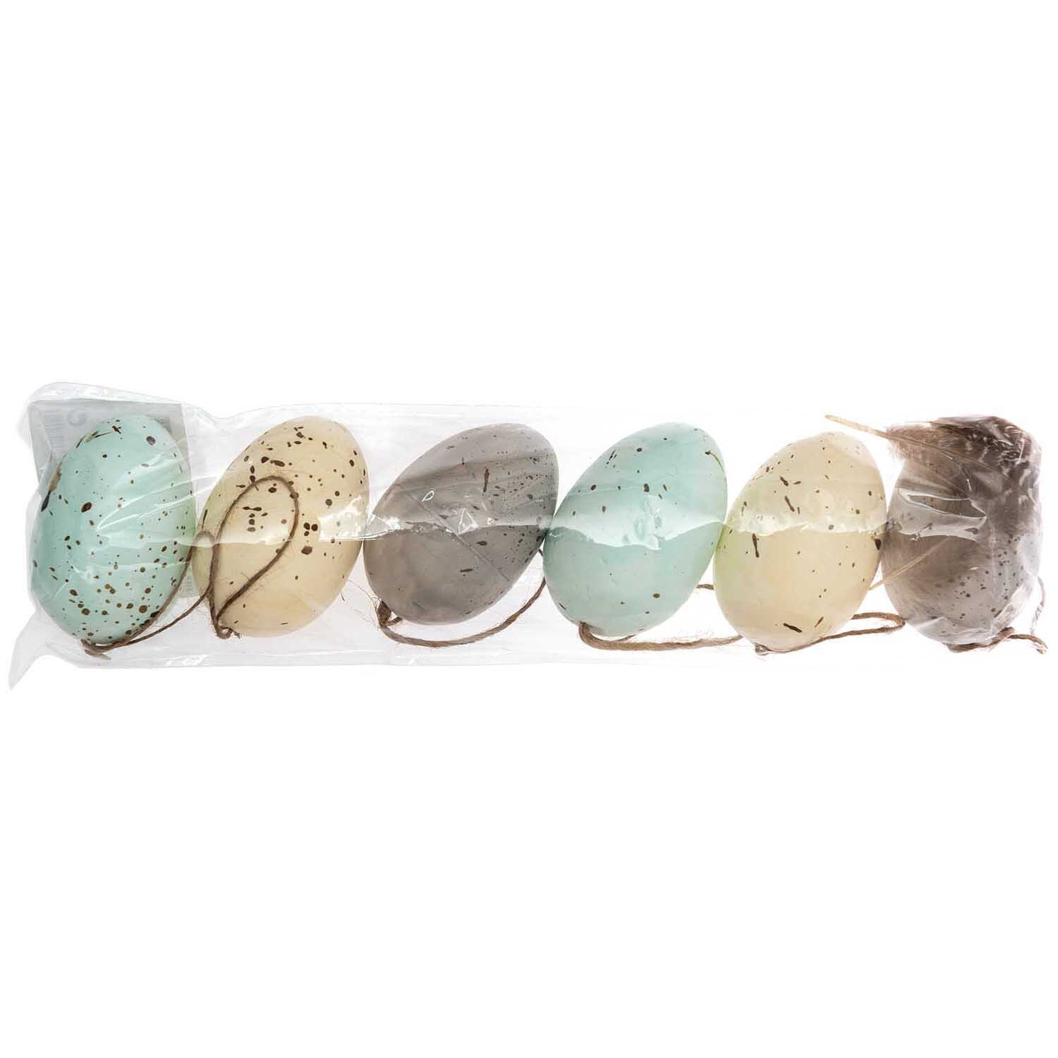 Eier mit Federn pastell Mix 6cm 6 Stück von Rico Design: Sechs pastellfarbene Eier in einer transparenten Verpackung, ideal für Dekorationen.