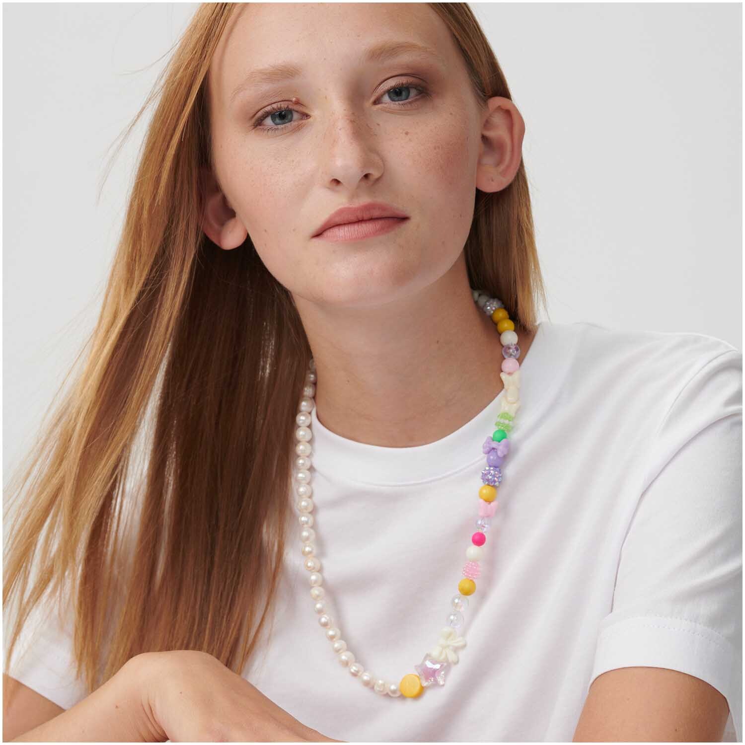 itoshii Stern Perlen holographisch, getragen von einer Frau mit weißem T-Shirt, bunte Perlenkette.