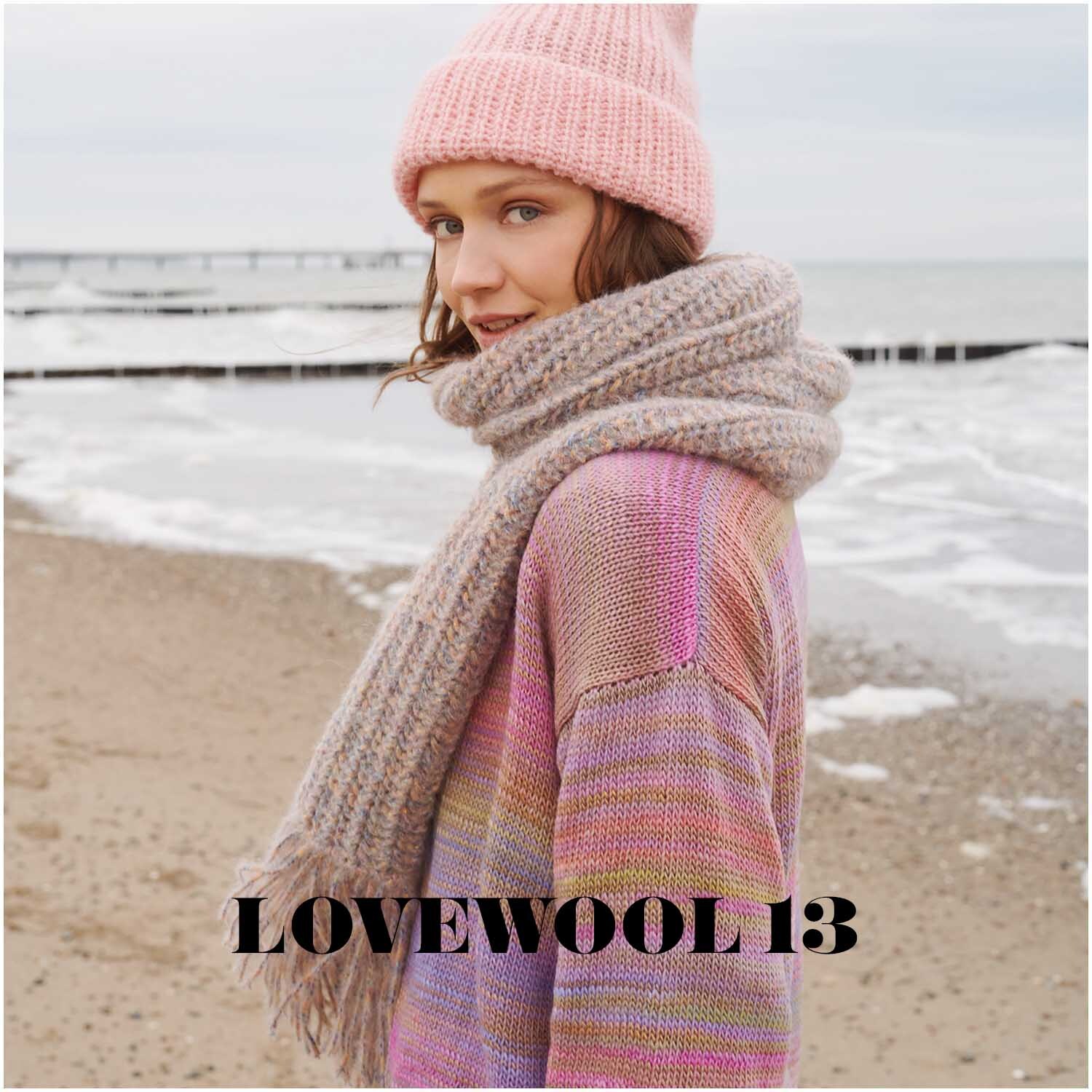 Fashion Alpaca BLING BLING: Frau am Strand in gestricktem Pullover und Schal in Pastelltönen, mit Mütze.
