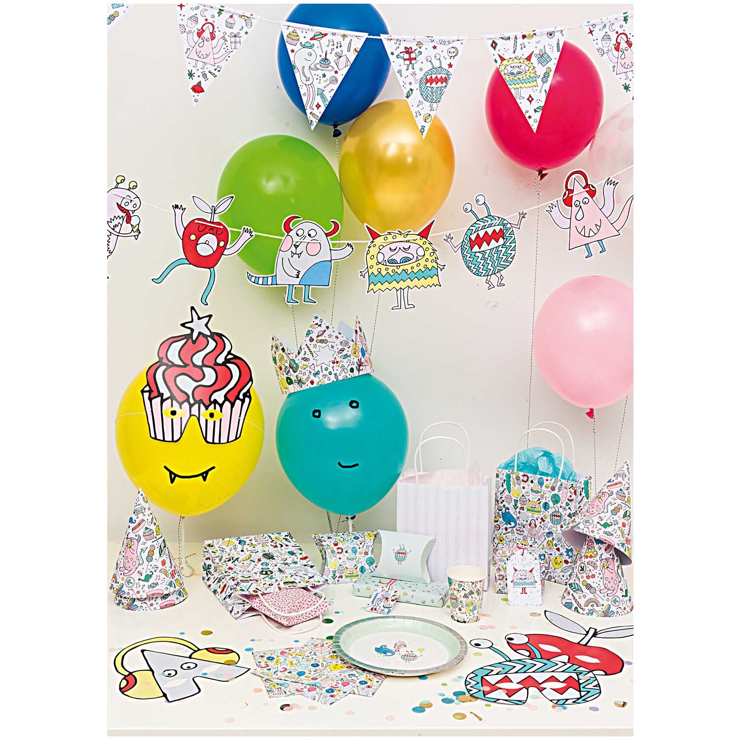 Paper Poetry Geschenkschachteln Monster Party mit bunten Luftballons und Partydekorationen.