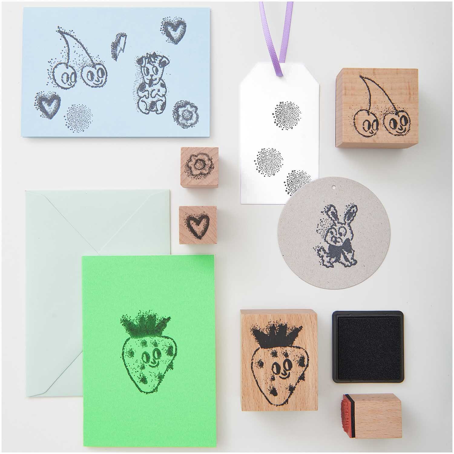 Paper Poetry Stempelset Airbrush: 12-teiliges Set von Rico Design mit verschiedenen Stempeln und Motiven auf Karten und Anhängern.
