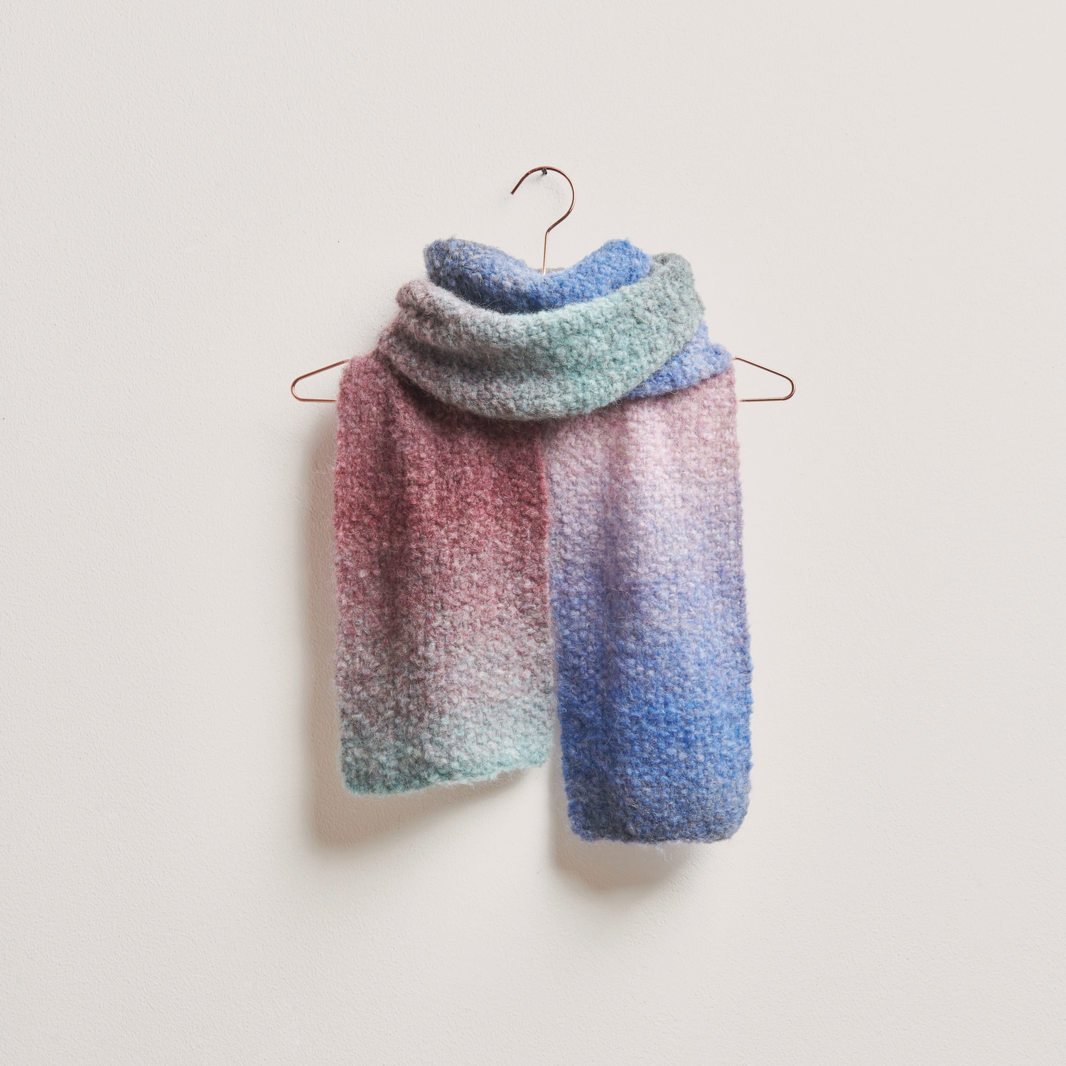 Fashion Alpaca Superfine Heavens Big Cloud Schal in sanften Blau- und Rosatönen, hängend an einem Haken. Ideal für Wintermode.