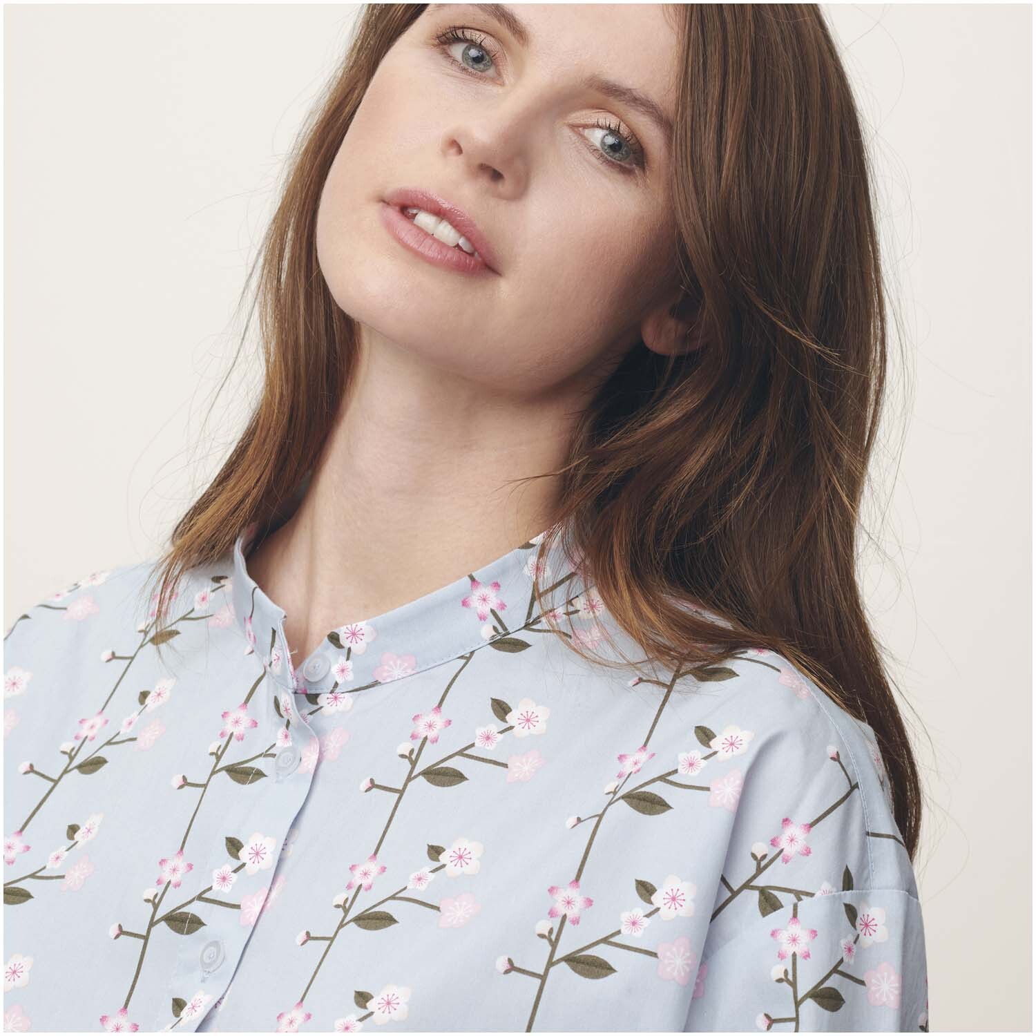 Stoffabschnitt Baumwoll-Popelin mit Sakura-Zweigen auf rauchblauem Hintergrund, ideal für elegante Nähprojekte.