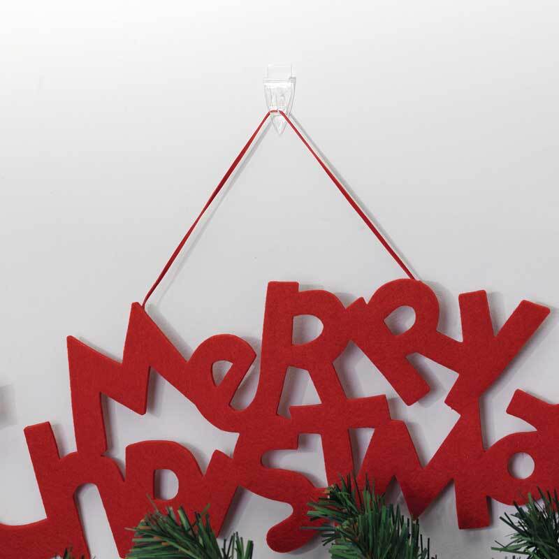 Powerstrips Decohaken kristallklar hält ein rotes "Merry Christmas"-Schild an der Wand. Ideal für saisonale Dekorationen.