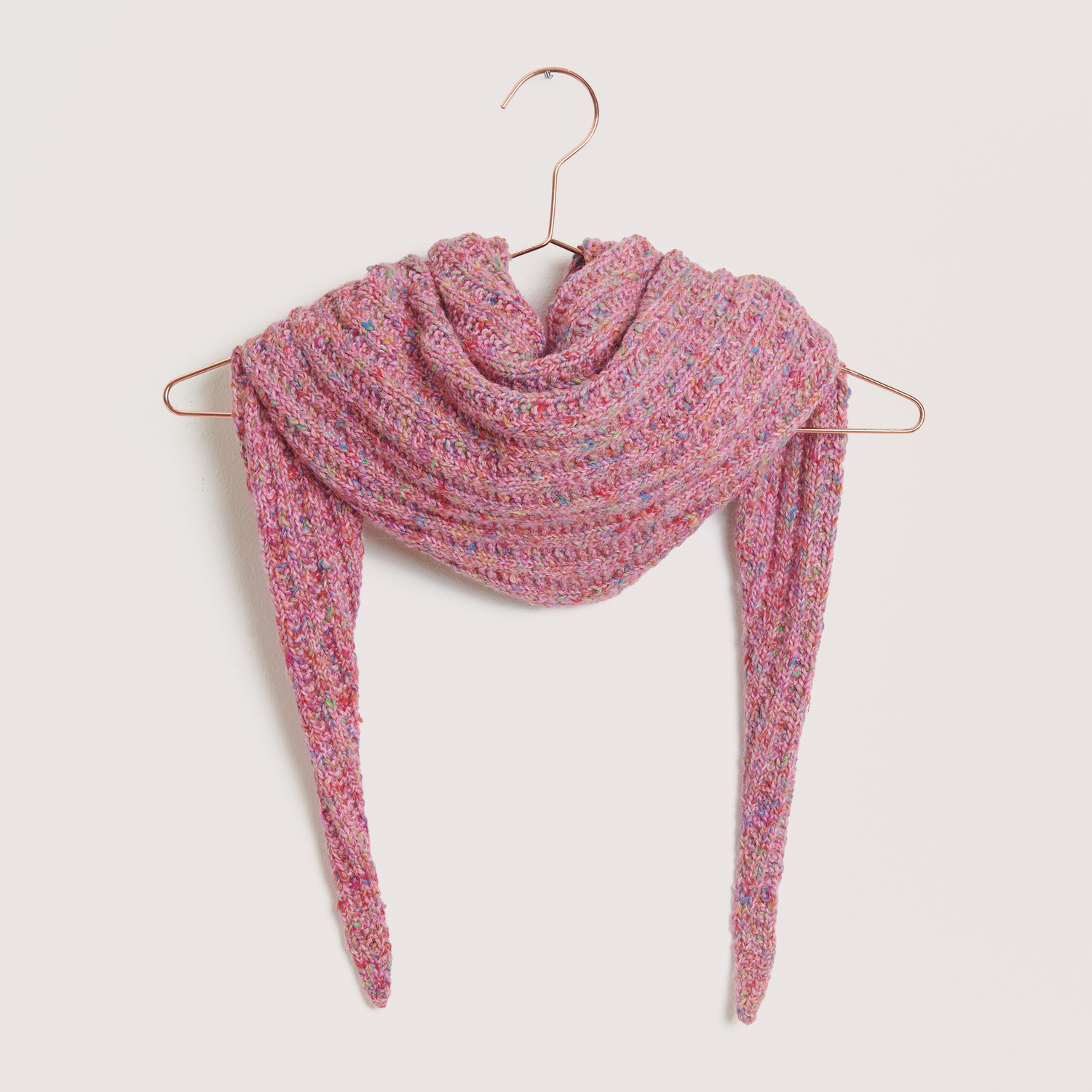Rico Design Fun Alpaka Cotton Blend aran Schal in Rosa auf einem Kleiderbügel, gestrickt aus weichem Garn, ideal für kühle Tage.