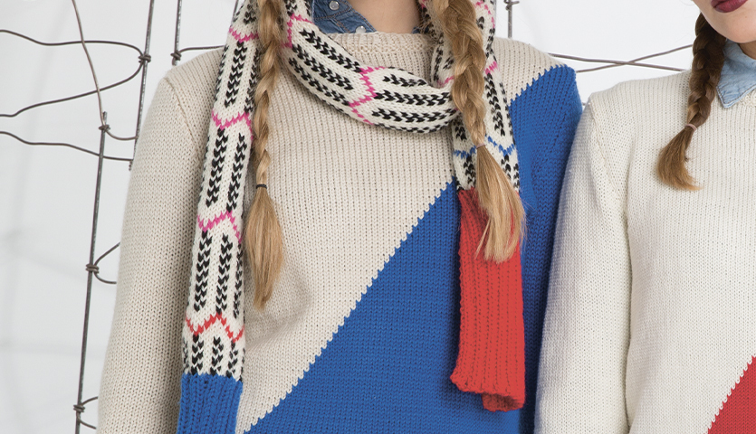 Strickanleitung Mütze und Schal aus Soft Merino: Frau trägt blau-weißen Pullover und gemusterten Schal.