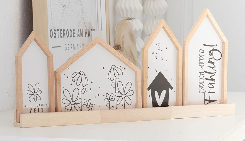 Inspiration Frühling Häuser Deko: Holzdekoration in Hausform mit Blumenmotiven und Schriftzügen.
