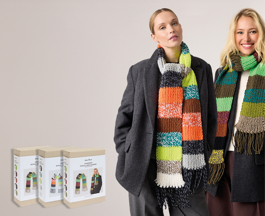 Zwei Frauen tragen jeweils einen gestrickten Schal aus verschiedenen bunten Garnen, daneben drei Stricksets für den Schal des Jahres.
