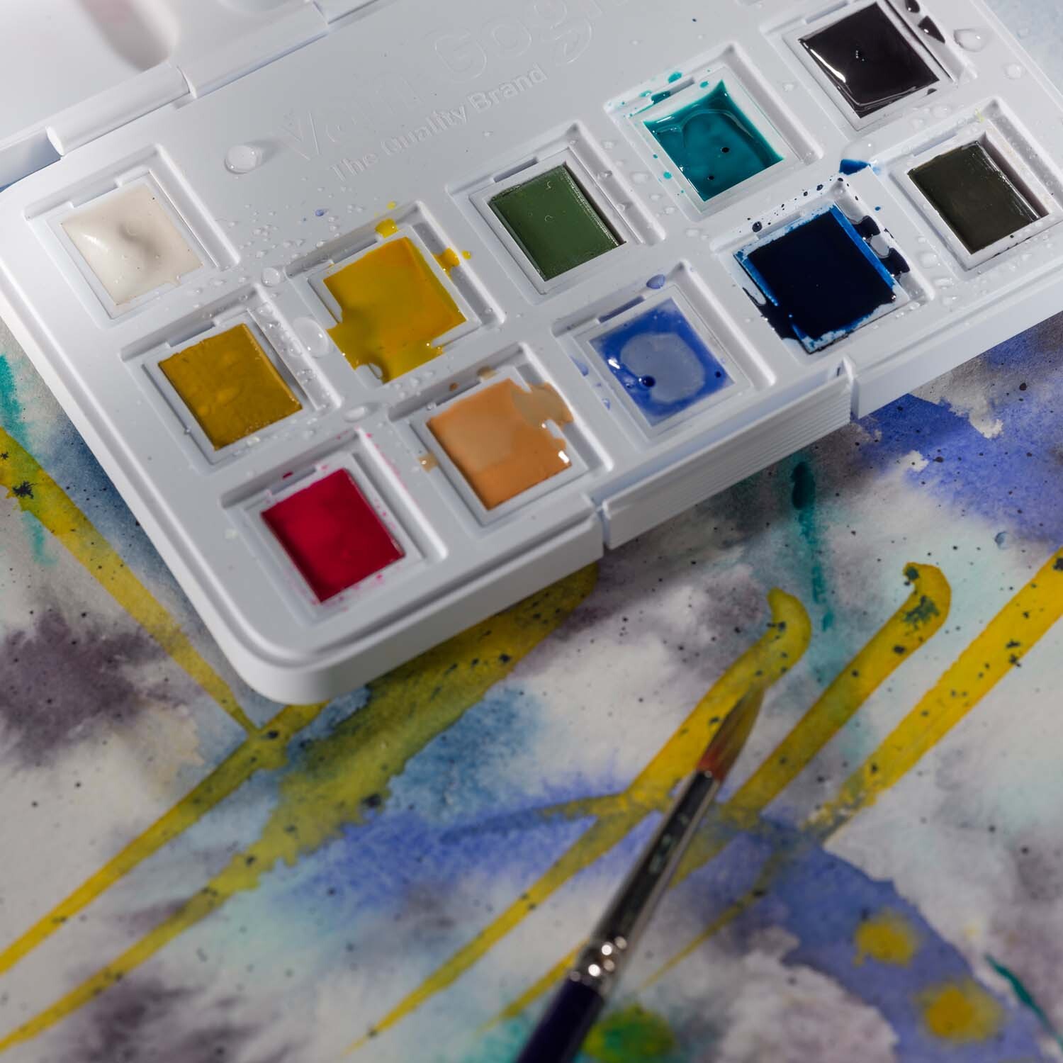 Aquarell Set gedeckte Farben 12 Näpfchen, van Gogh. Geöffnete Palette mit Pinsel auf Aquarellpapier.