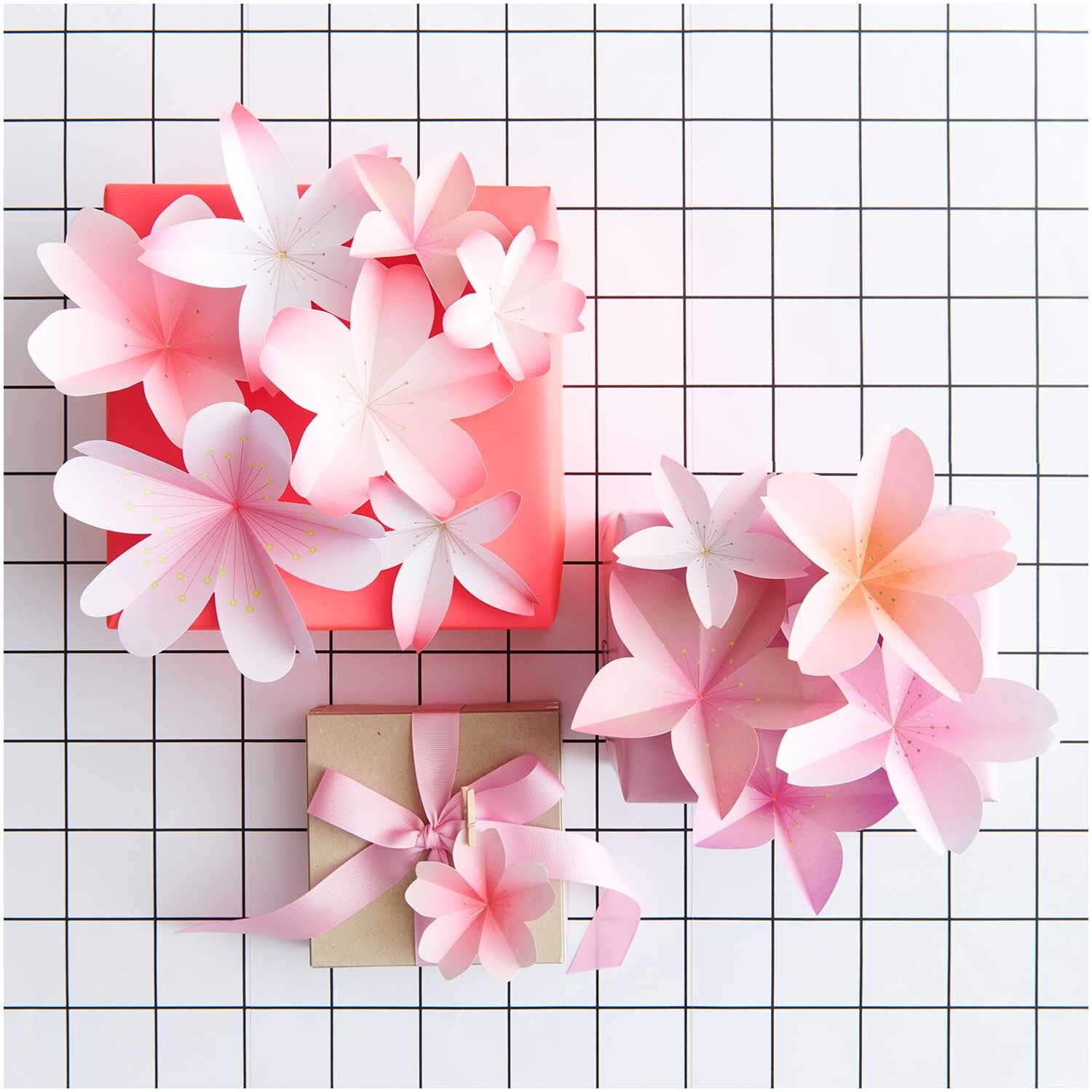 Paper Poetry Papierblüten Luxury Sakura: Zarte Papierblüten in Rosa auf kariertem Hintergrund, ideal für Dekorationen.