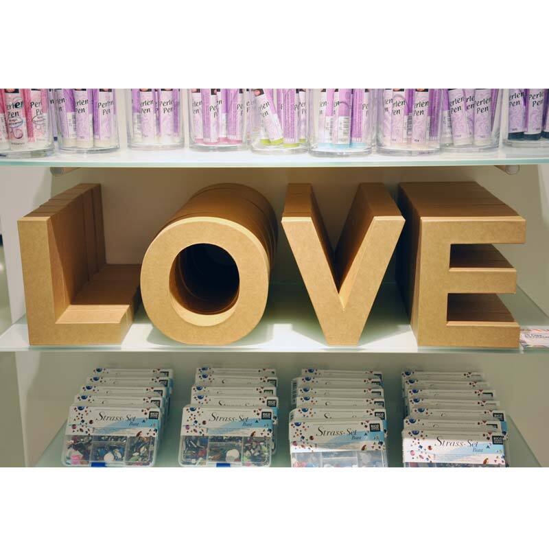 Pappbuchstabe & zeigt große, stehende 3D-Buchstaben aus Pappe, die das Wort "LOVE" bilden. Ideal für kreative Dekorationen.