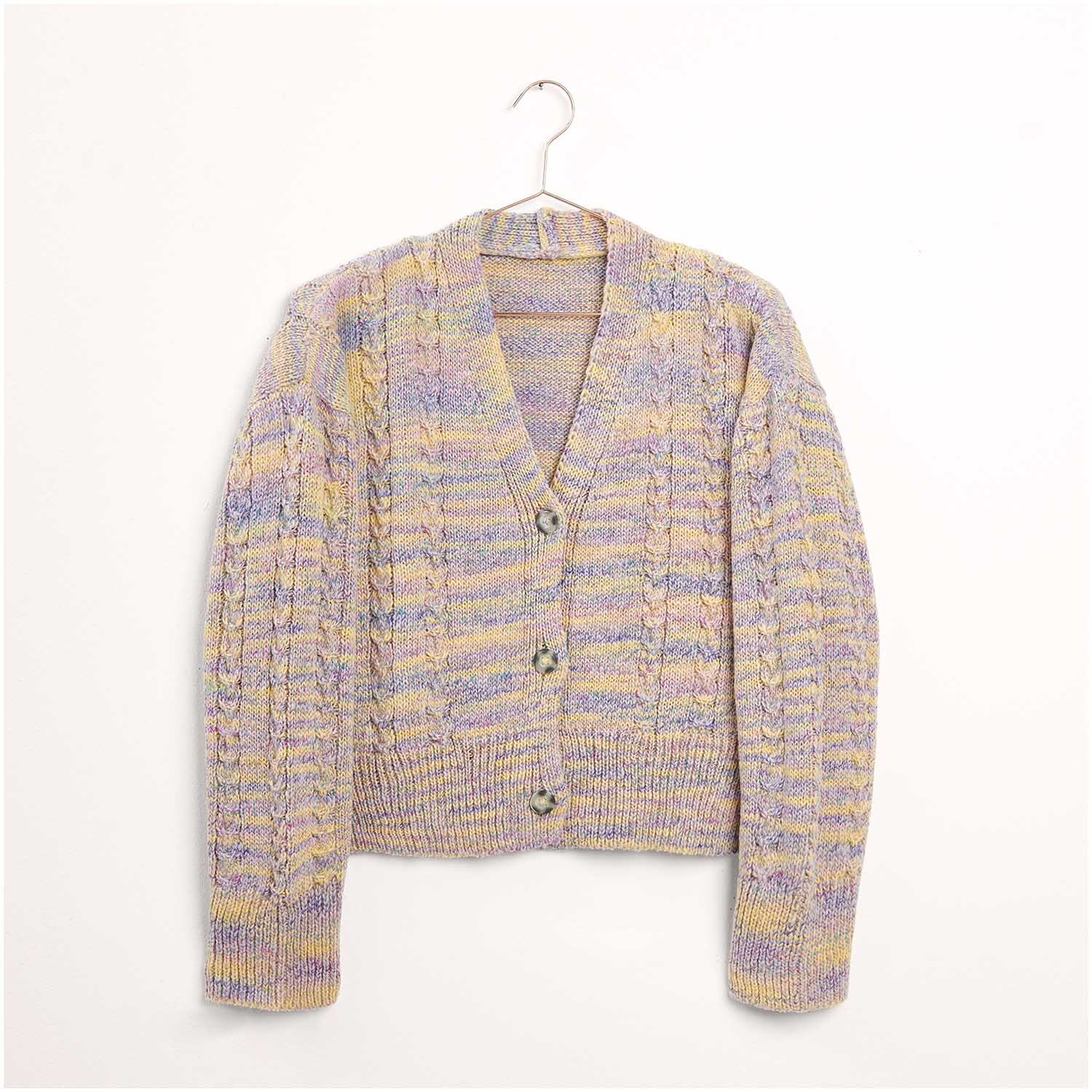 Strickset Jacke Modell 06: Eine gestrickte Jacke in Pastelltönen mit Knöpfen, hängend an einem Kleiderbügel.