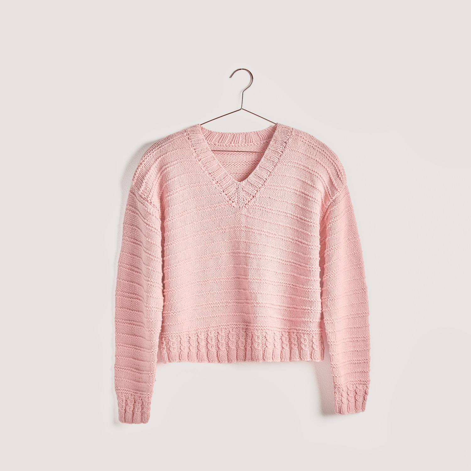 Strickset Pullover Modell 15 aus Vegan Cashmere in Altrosa, präsentiert auf einem Kleiderbügel. Ideal für nachhaltige Modeprojekte.