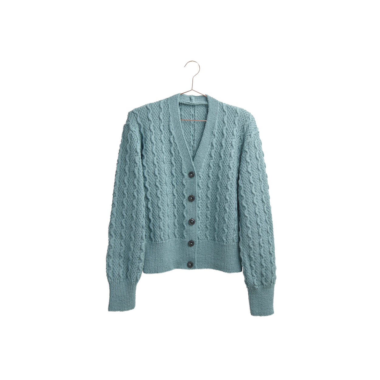Eine blaue gestrickte Jacke mit Wellenmuster hängt an einem Kleiderbügel.