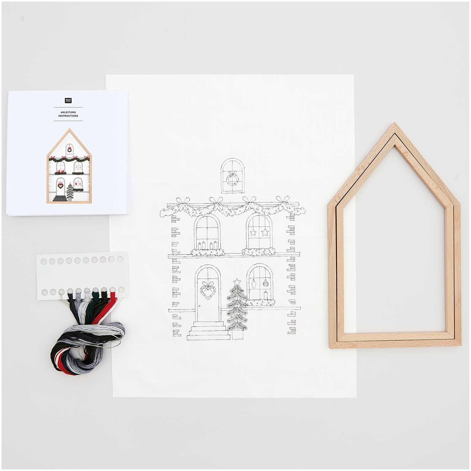 Stickpackung Haus groß vorgezeichnet 16x27cm von Rico Design mit Holzrahmen, Garn und Anleitung auf weißem Hintergrund.