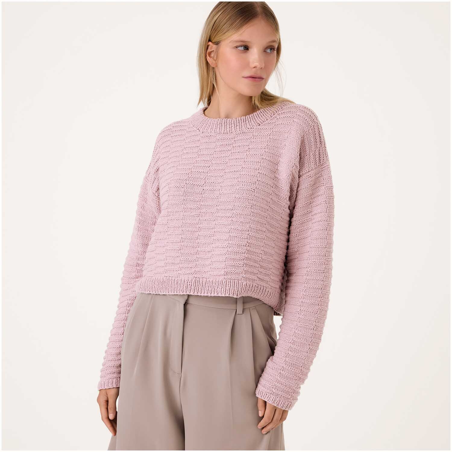 Luxury Organic Cotton Silk dk: Frau trägt altrosa Strickpullover von Rico Design, kombiniert mit beigen Hosen.
