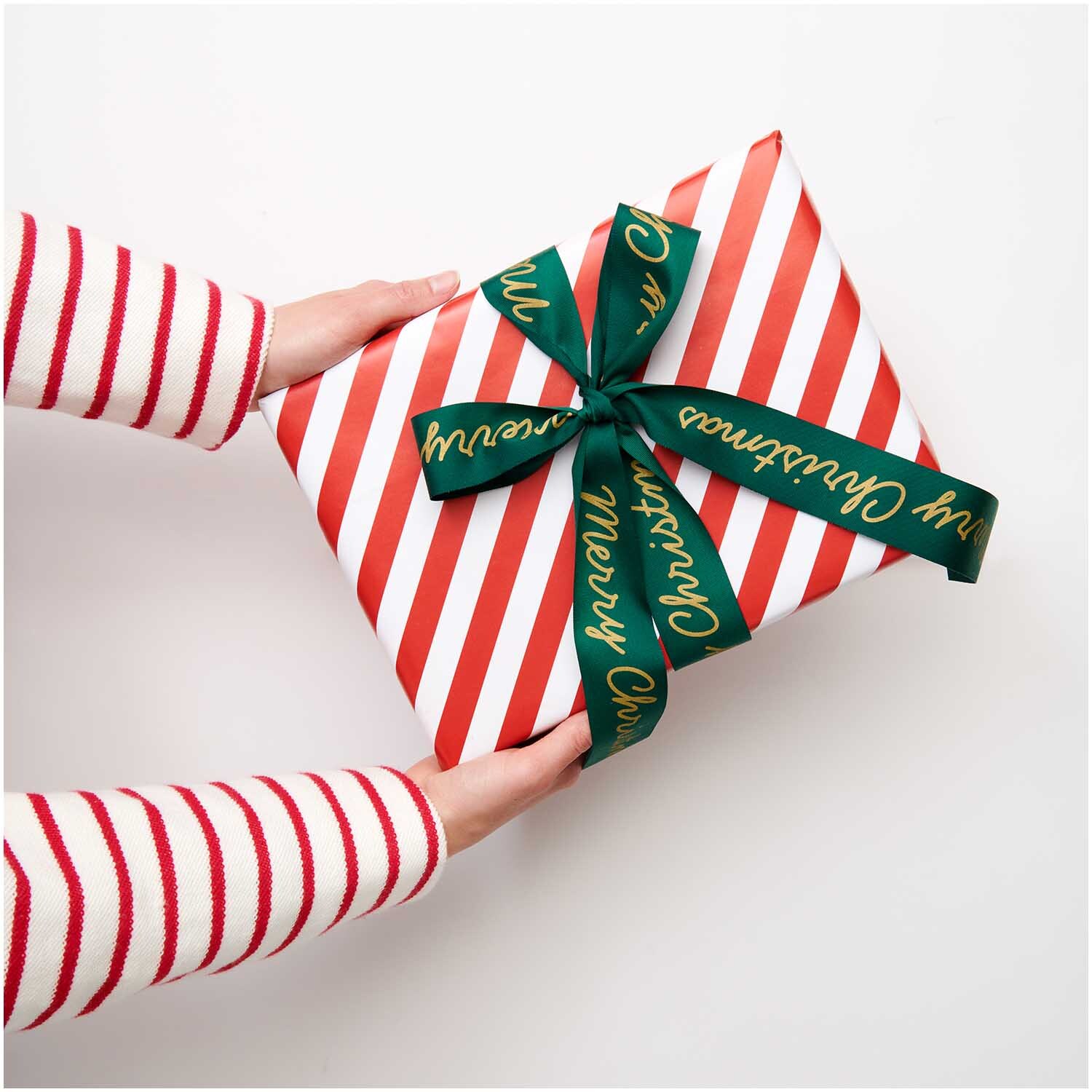 Paper Poetry Taftband Merry Christmas: Ein Geschenk mit rot-weißem Streifenpapier und grünem Band von Rico Design.