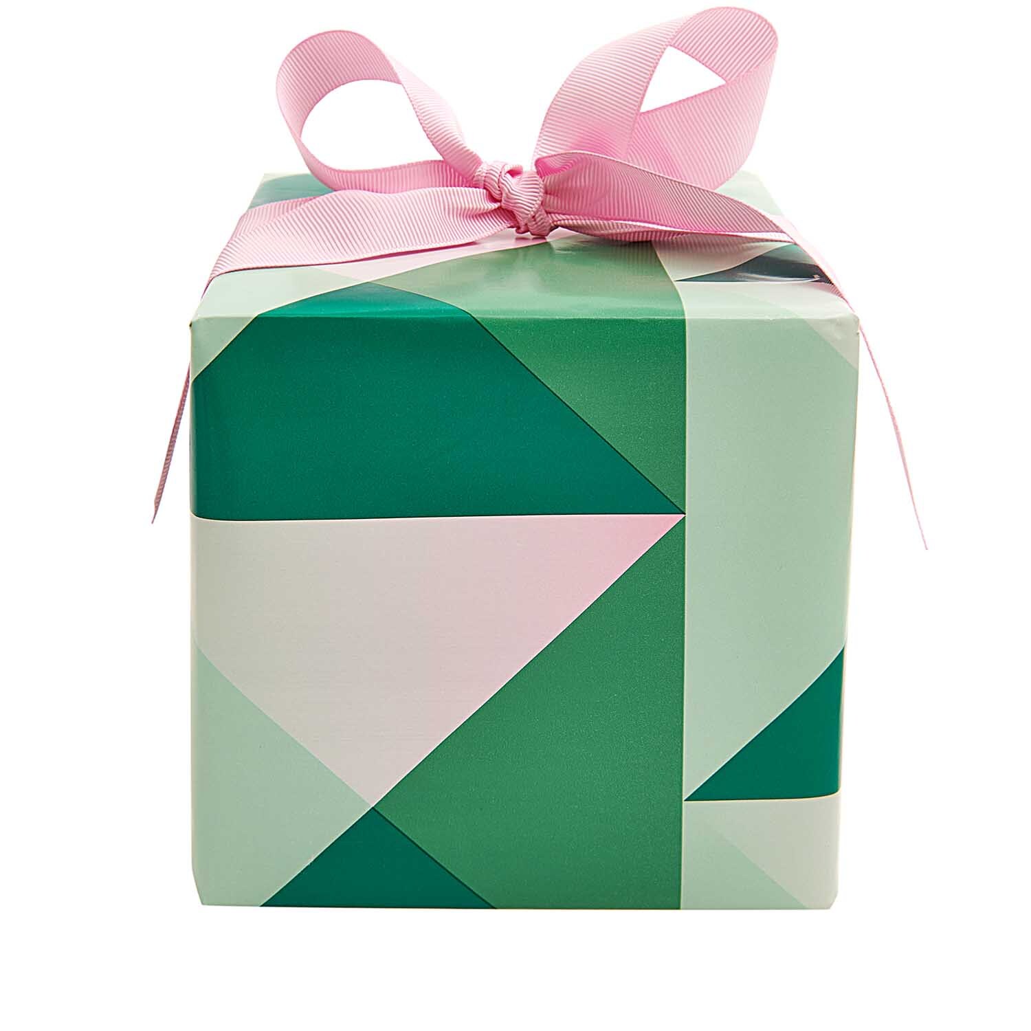 Paper Poetry Geschenkpapier mit geometrischem Muster, verpackt als Geschenk mit rosa Schleife.