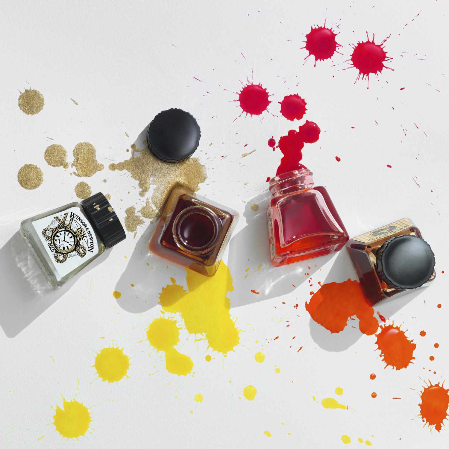 Zeichentusche 14ml von Winsor & Newton in verschiedenen Farben, mit offenen Flaschen und Farbspritzern auf weißem Hintergrund.
