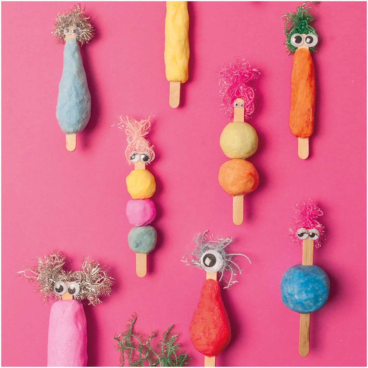 Knetseife weiß-opak 300g: Bunte Figuren aus Knetseife auf pinkem Hintergrund, dekoriert mit Augen und Haaren. Ideal für kreative Bastelprojekte.