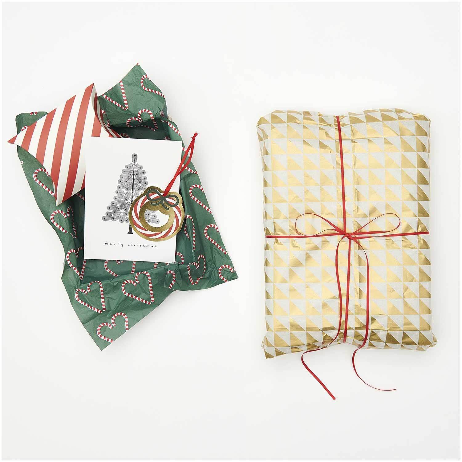 Paper Poetry Seidenpapier Dreiecke gold-weiß 50x70cm, dekorativ verpackt mit rotem Band, neben Weihnachtskarte und Geschenkpapier.