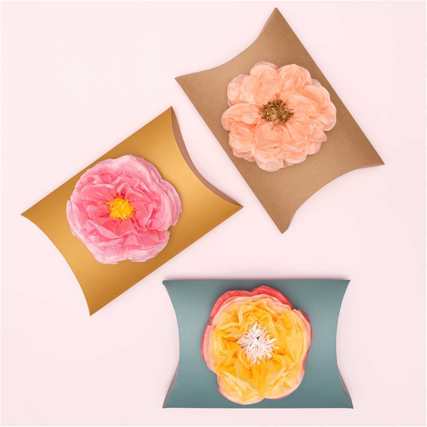 Floristenkrepp von Rico Design in drei Farben, dekoriert mit großen, farbenfrohen Papierblumen.
