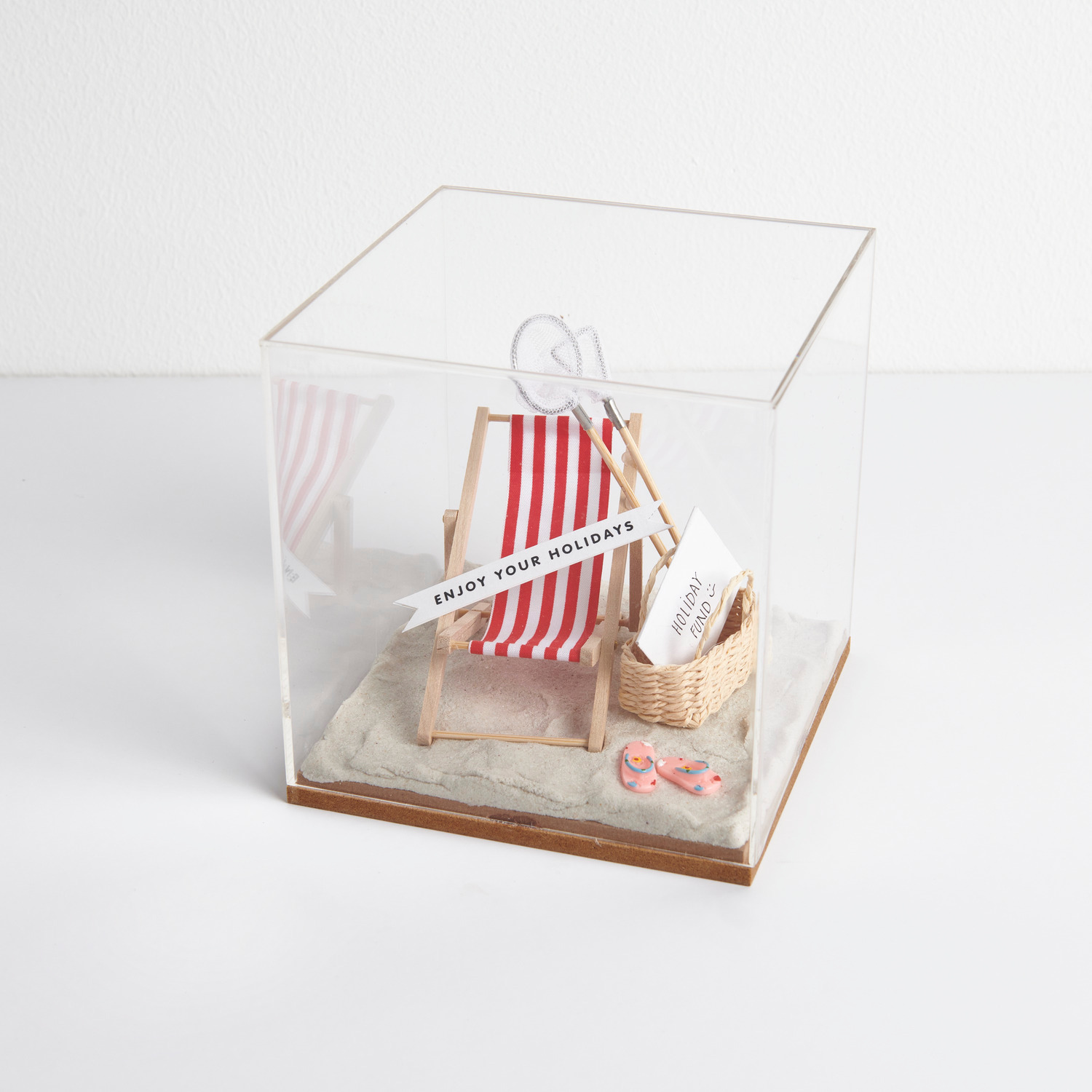 Miniatur Flip Flops in Dekohaube mit gestreifter Strandliege, Fischkescher und ovalem Korb.