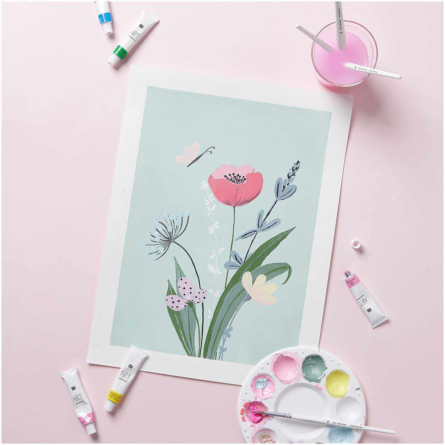 Anleitung Gouacheblumen malen: Pastellfarbene Blumenillustration mit Malutensilien auf rosa Hintergrund.