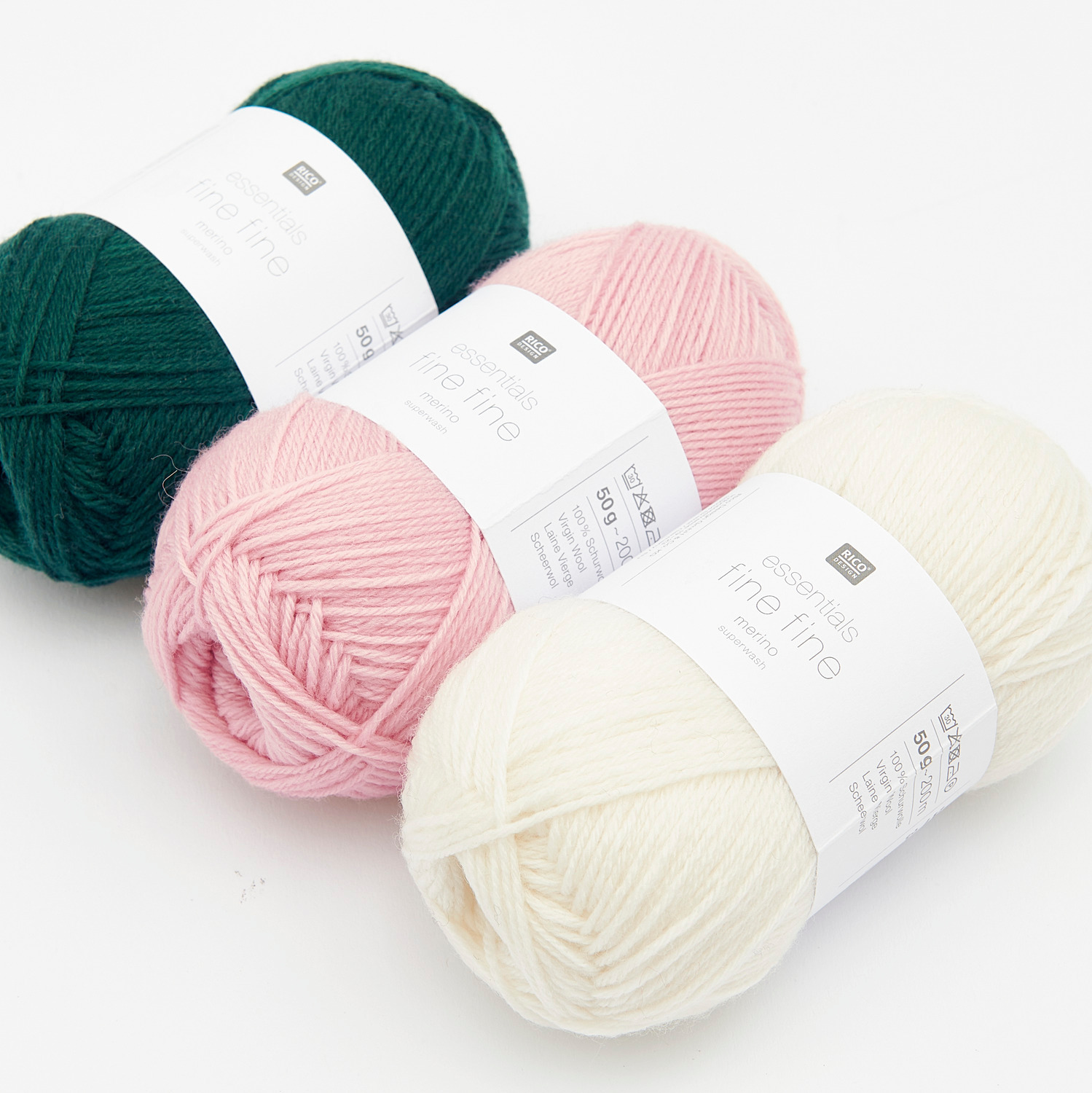 Essentials Fine Fine Merino Wolle in Rosa, Dunkelgrün und Weiß von Rico Design, 50g Knäuel, 200m Länge.